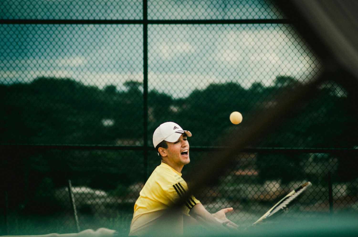 Action shot of people playing racket sport outdoors, capturing dynamic movement in a landscape orientation.