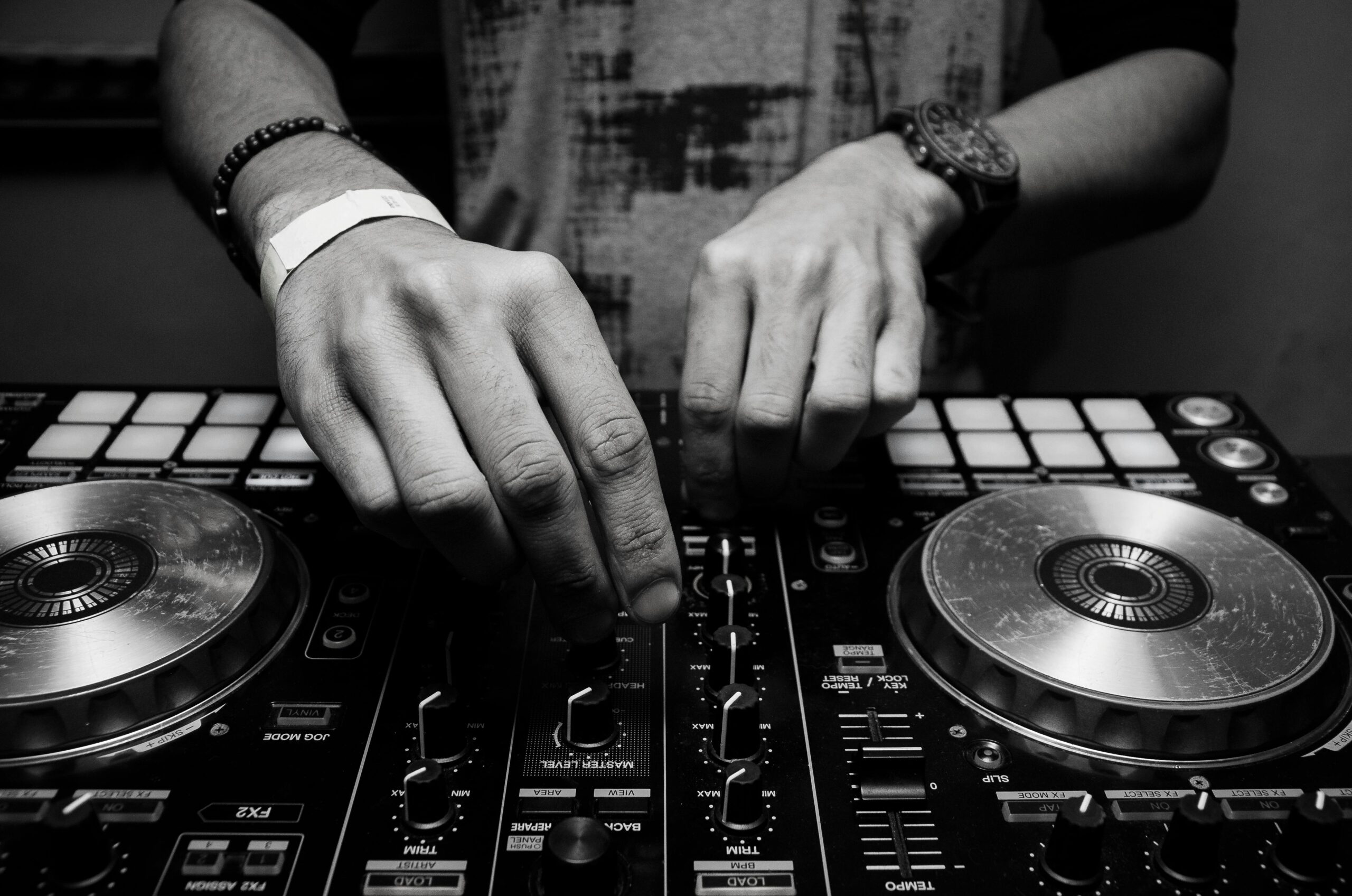 A DJ performing live, skillfully using a crossfader to blend two tracks seamlessly.